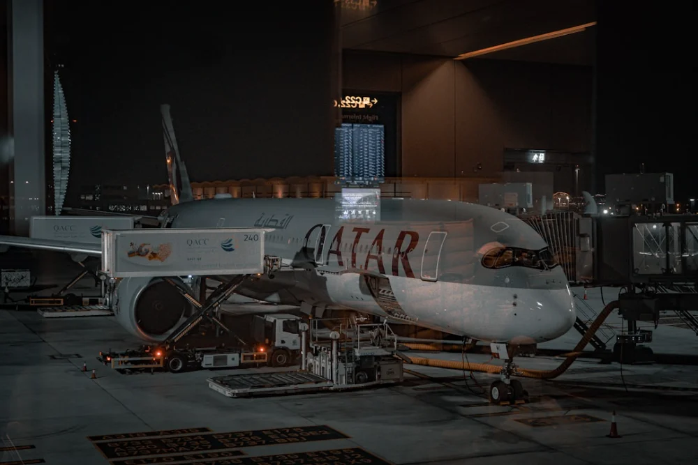 An airplane is parked on the tarmac at night