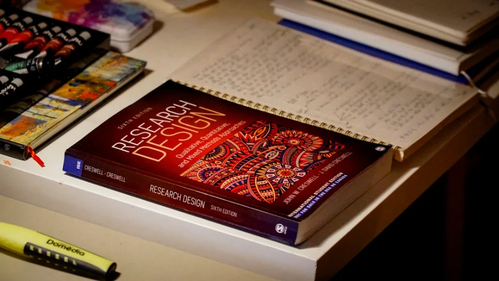 Research design book on a desk with notebooks
