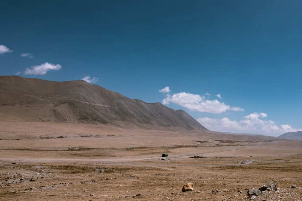 Vast desert landscape with mountains under a blue sky
