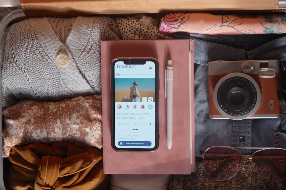 an open suitcase with a cell phone and other items