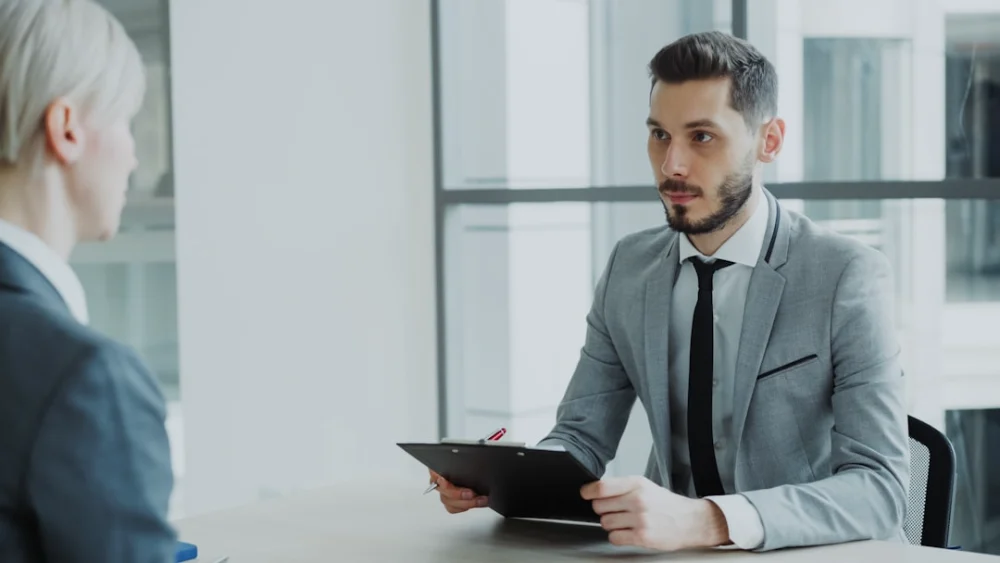 Two people in a business meeting with a clipboard