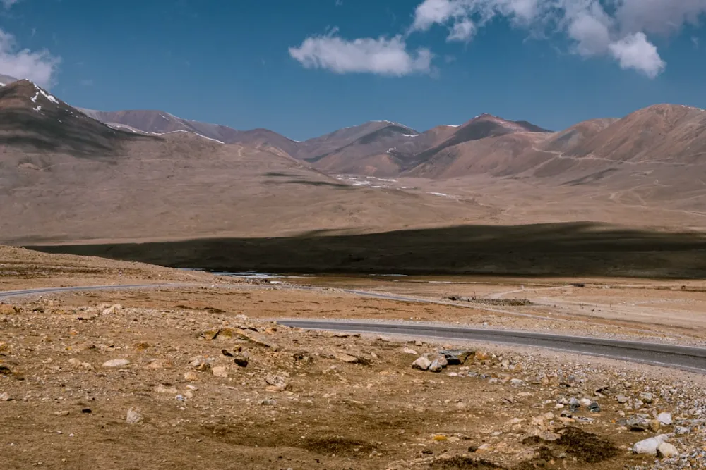 A winding road through a vast, arid mountain landscape