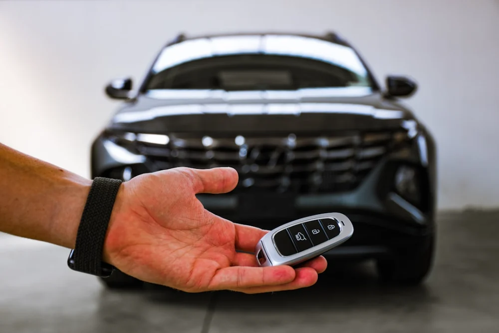 person holding black and silver audi car steering wheel