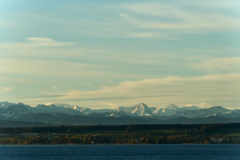 Snow-capped mountains rise above a green landscape