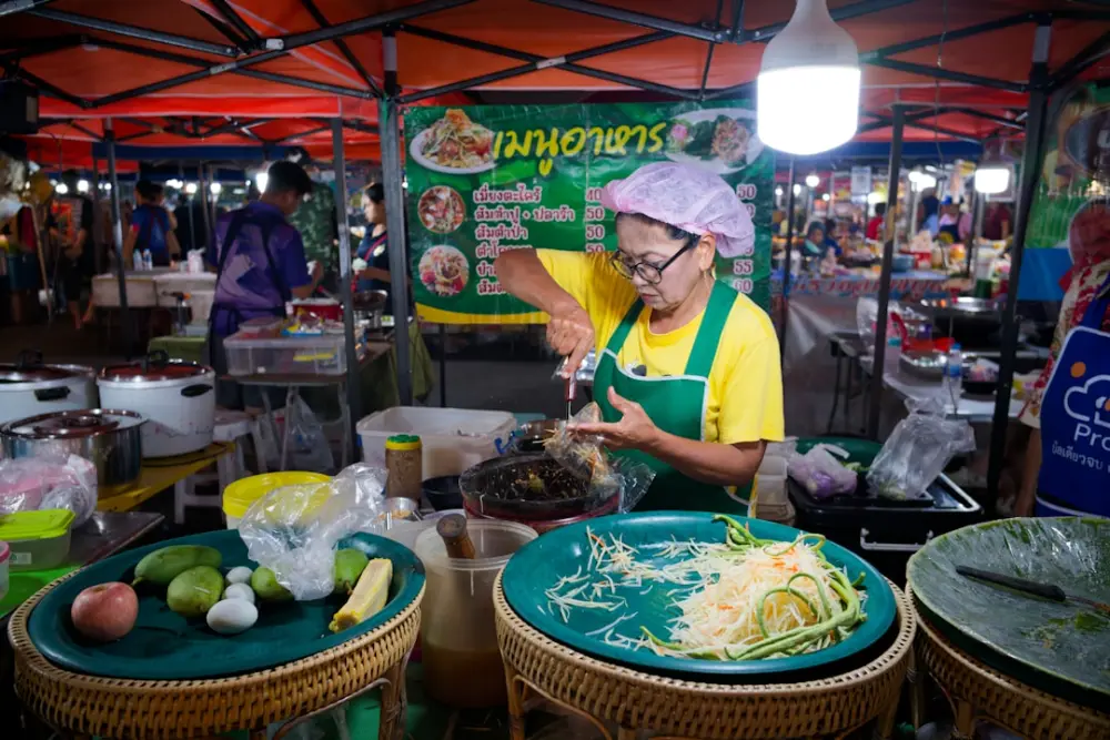Woman preparing food at a busy night market stall