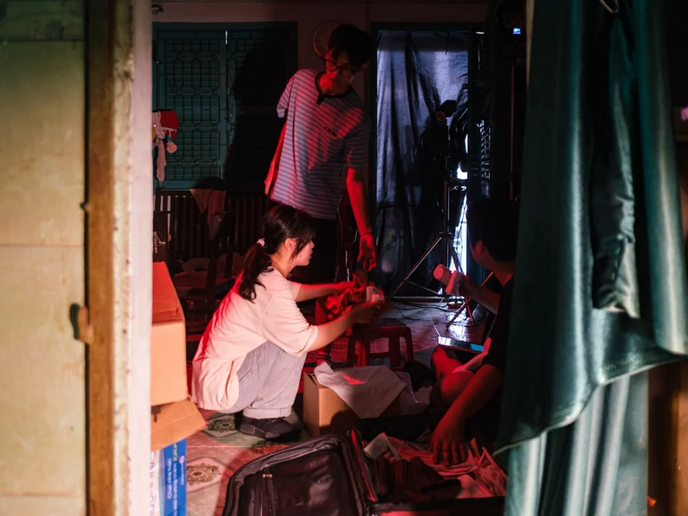 People in a cluttered, dimly lit room
