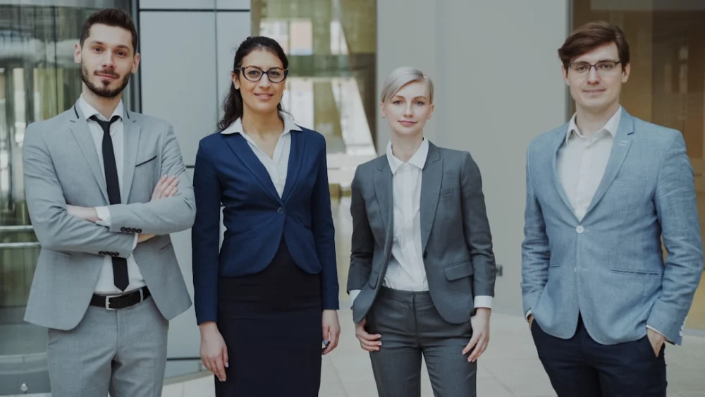 Four business professionals standing together indoors
