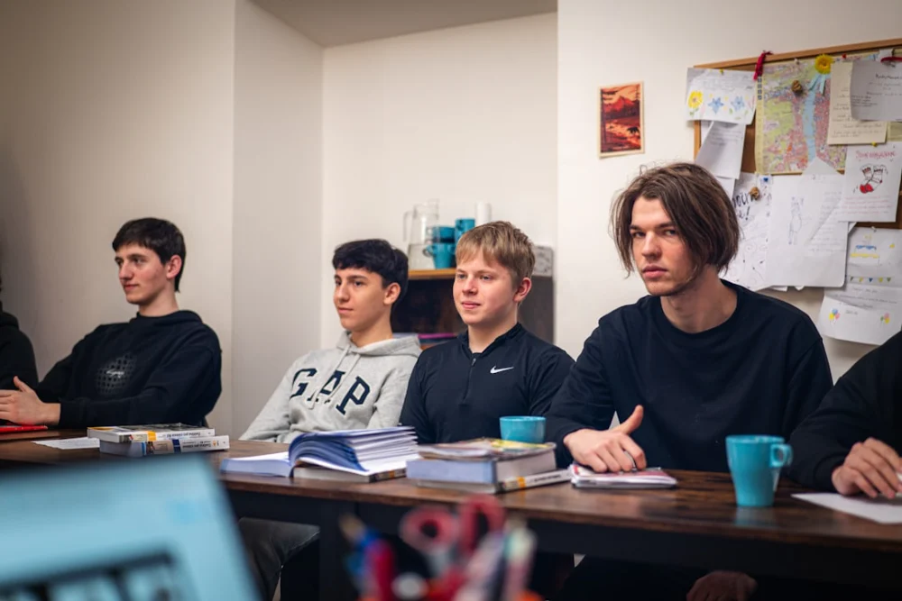 Young men attentively listening in a classroom setting