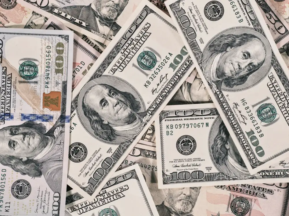 A scattered pile of American one hundred dollar banknotes