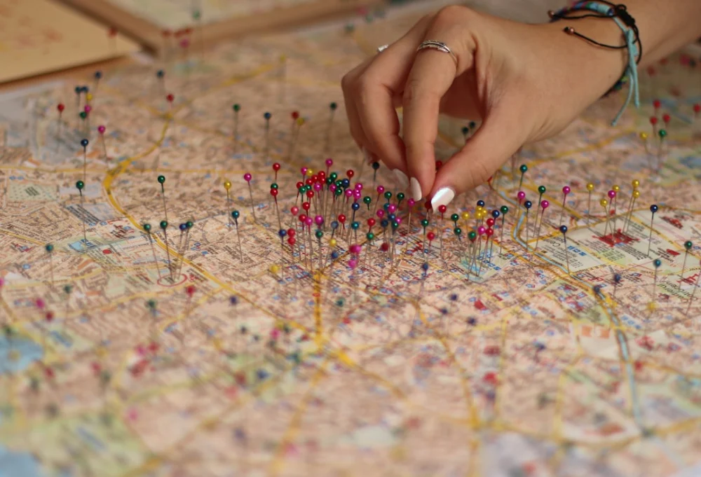 A person is putting pins on a map