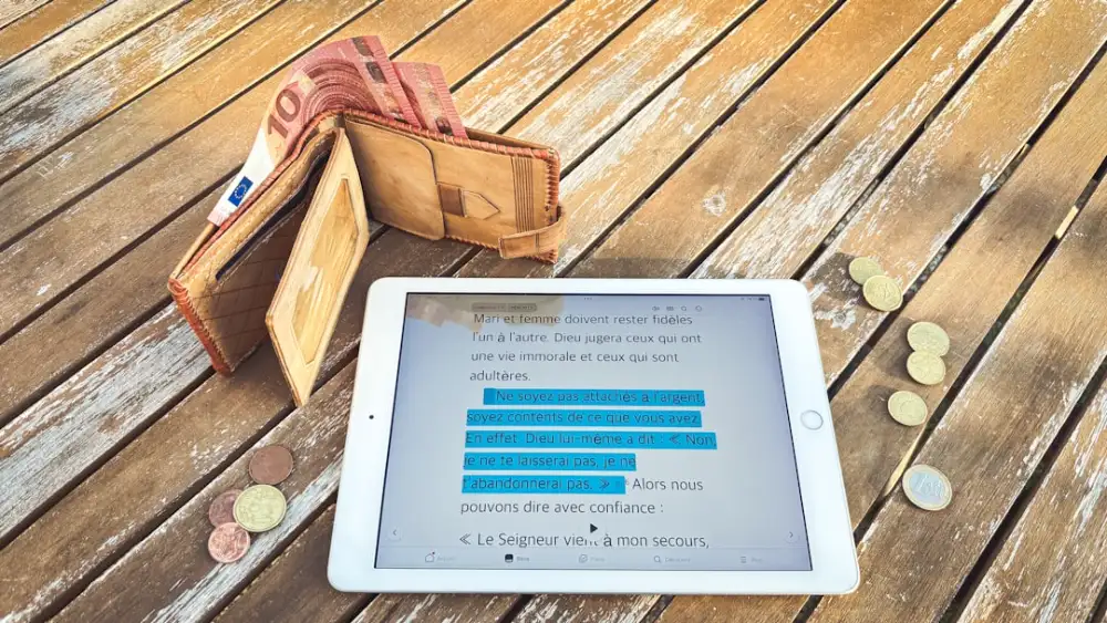 Euro wallet, tablet with chart, and coins on wooden table