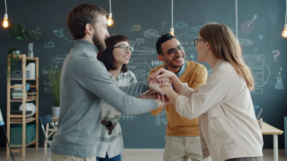 Diverse team celebrates success with a huddle
