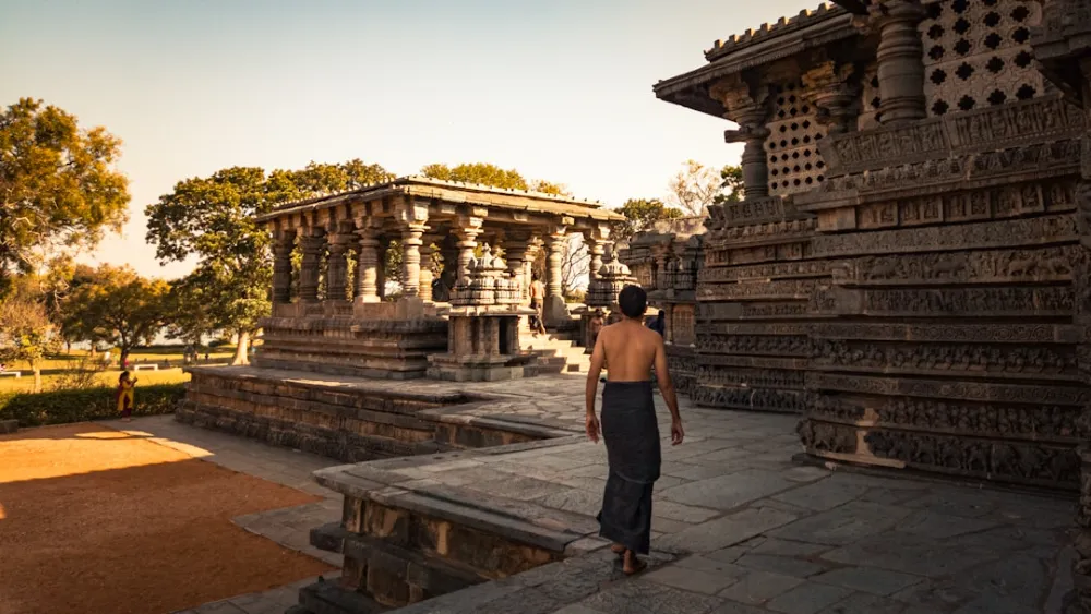 Man walking towards ancient stone temple architecture