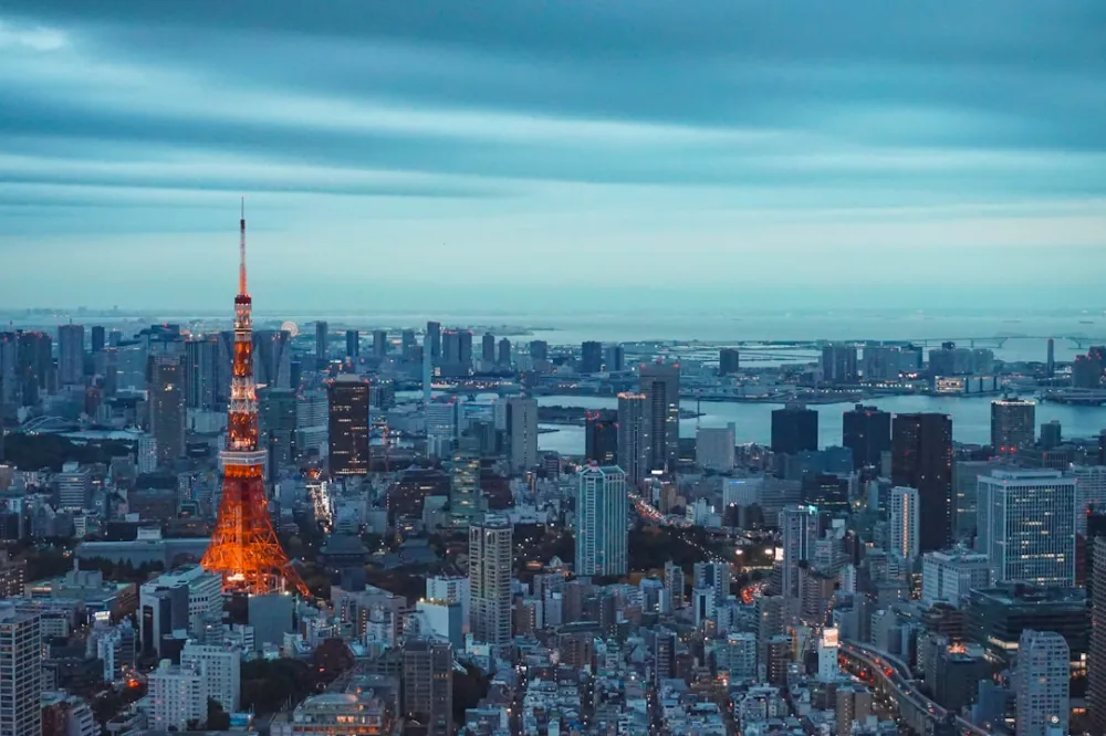 tokyo tower illuminated at dusk with city skyline