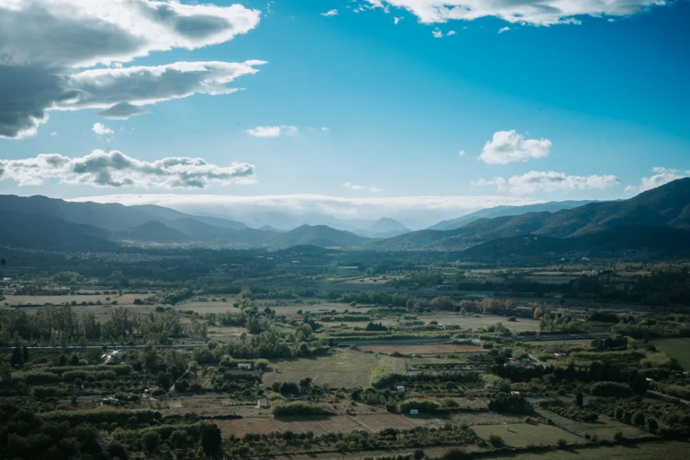 An aerial view of a valley with mountains in the background