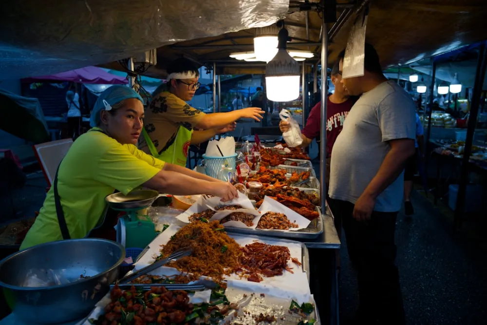 Vendors serve food at a busy night market stall
