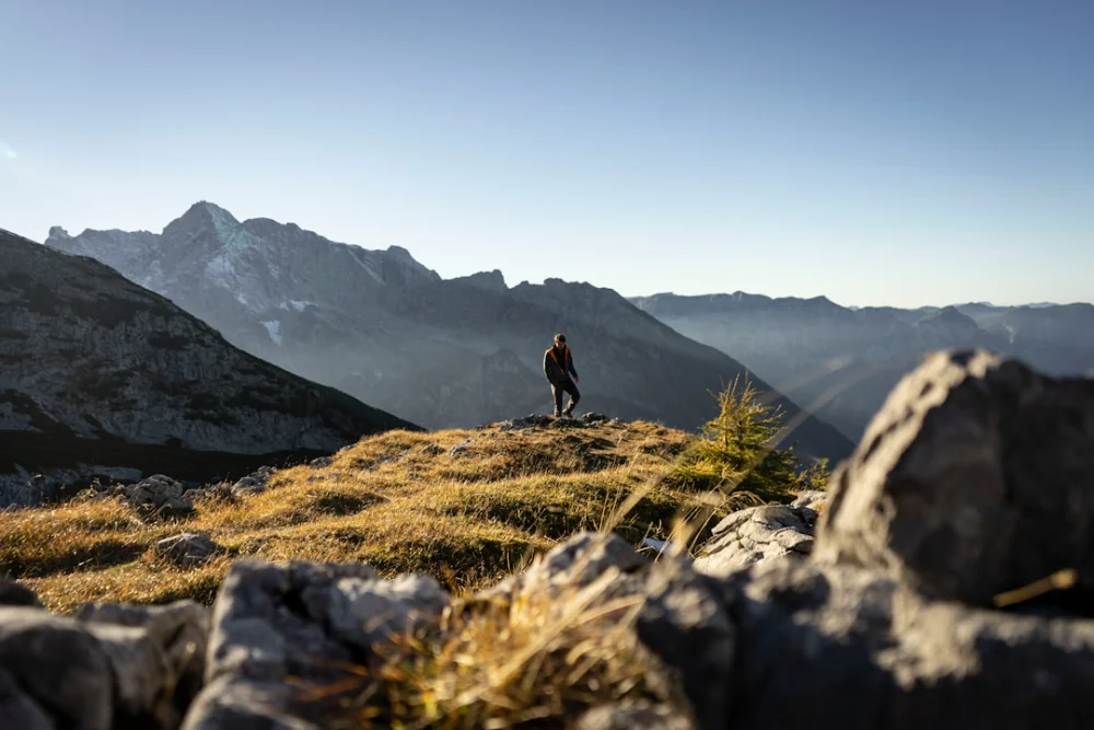 person standing on gray rocky mountain