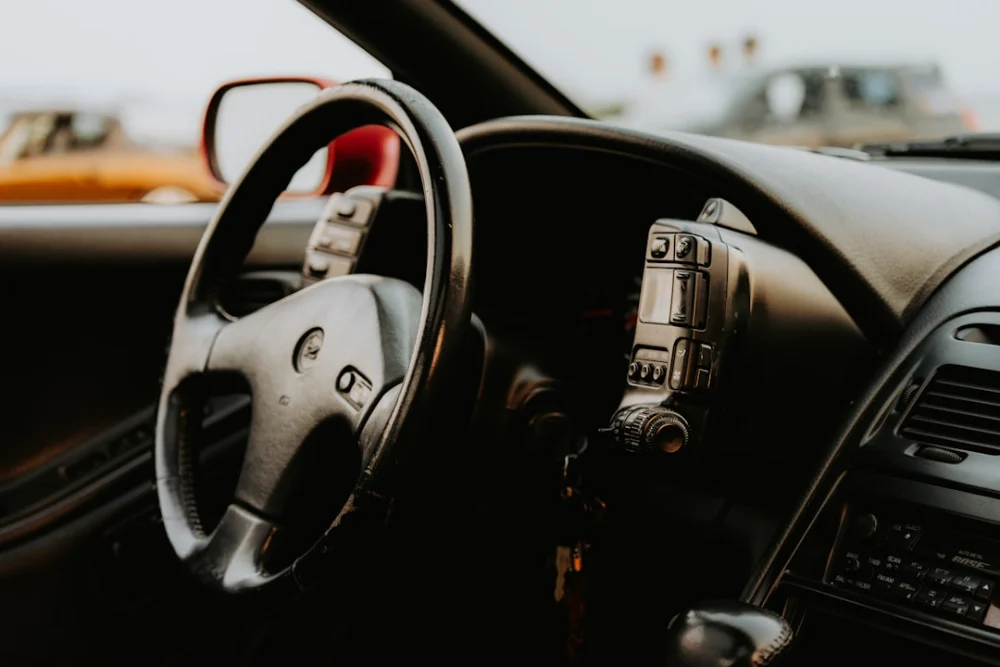 A close up of a steering wheel and dashboard of a car